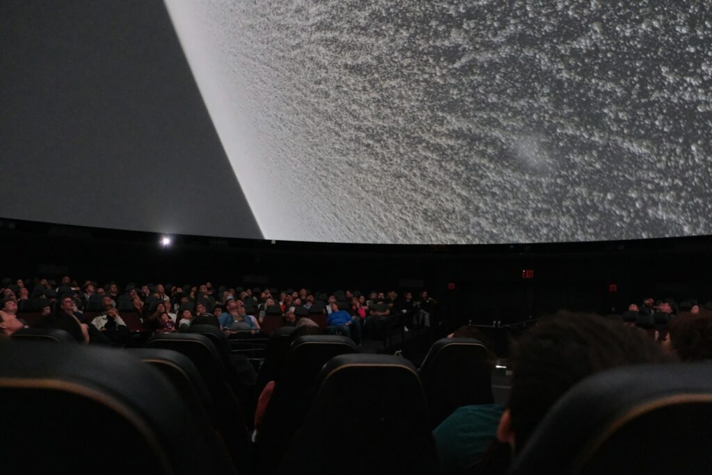 a crowd of people watching future of cinema on screen